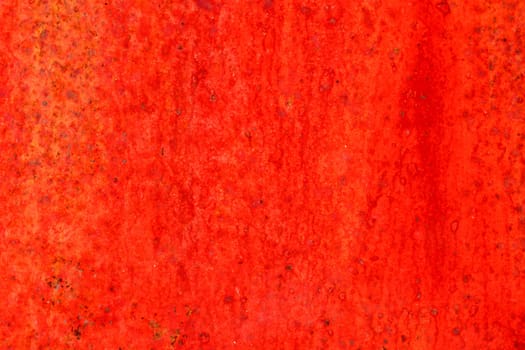 Red metal and paint creating textured wall background