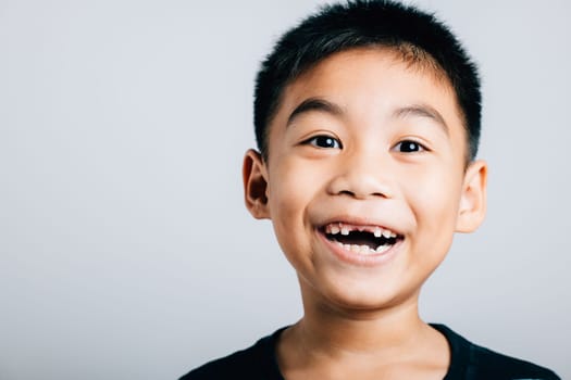 Smiling schoolboy cheeky grin showing lost milk tooth gap. Child dental care isolated on white. Joyful development tooth change dental hygiene. Children show teeth new gap, dentist problems