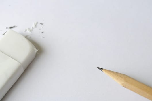 Top view of eraser and pencil on white cover background with customizable space for text.