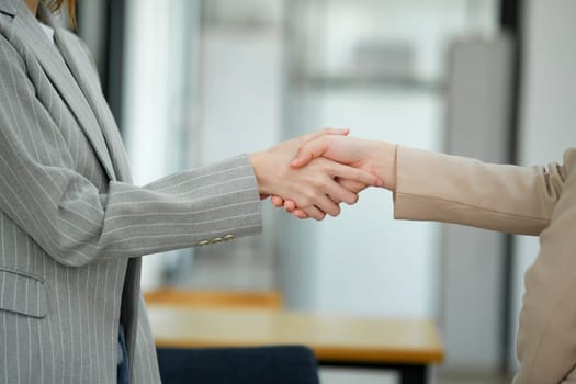 Close-up view of a firm handshake between two businesswomen, representing a professional agreement or partnership..