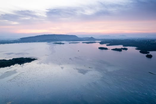 Aerial drone shot showing sunrise dawn dusk over aravalli hills lake pichola fateh sagar and cityscape in Udaipur, Chandigarh, Nainital showing famous tourist spot in India