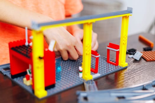 Close-up of a child's hands assembling a toy construction set with colorful pieces, focusing on creative play and development.