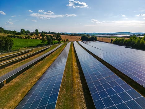 Solar panels in rows on a solar farm in the countryside in sunshine in autumn