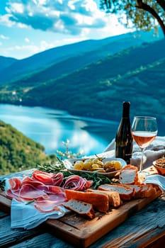 Sausages, cheeses and wine on the shore of a mountain lake. Selective focus. Food.