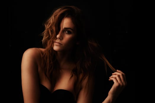 Woman, hair care and ginger with portrait, serious and shampoo treatment in a studio. Relax, beauty and female person with wavy texture and fresh haircut with balayage coloring with black background.