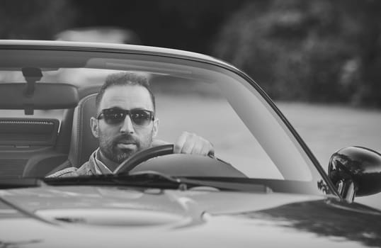 Zaandam, Netherlands, August 29, 2023: Attractive man in a cabriolet.