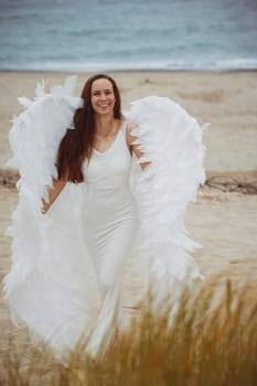 Sondervig, Denmark, August 22, 2023: Beautiful girl dressed as angel on the sea