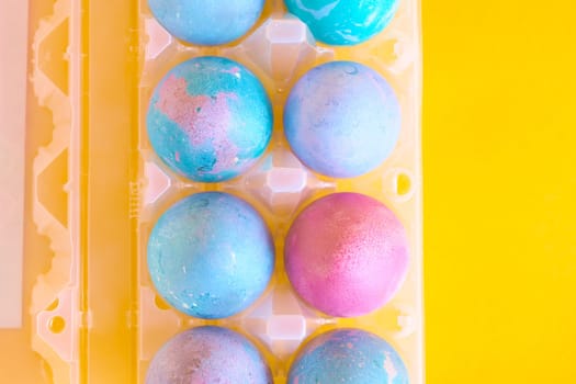 Painted Easter eggs with space intergalactic pattern in stand on yellow background
