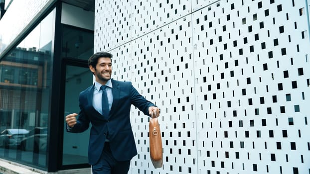 Skilled business man dancing with joyful while walking in city street. Project manger receive a good news, getting promotion, getting a successful job while express feeling of overjoy. Exultant.