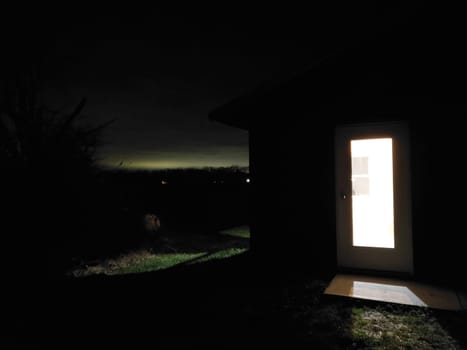 View of a Door with a window Showing a Bright Room with a Dark Horizon in the Background