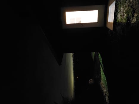View of a Door with a window Showing a Bright Room with a Dark Horizon in the Background