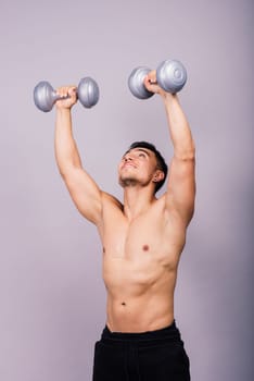 Shirtless bodybuilder showing his great body and holding dumbells.
