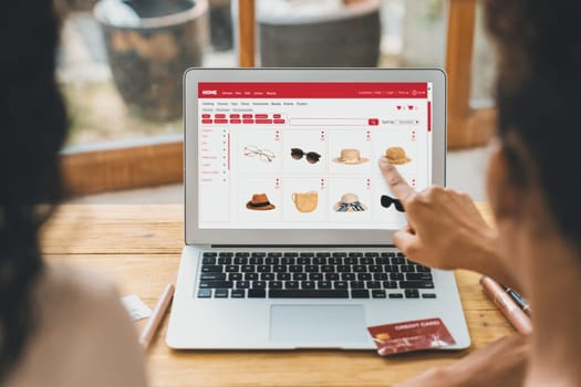 Woman shopping online on internet marketplace browsing for sale items for modern lifestyle and use credit card for online payment from wallet protected by crucial cyber security software