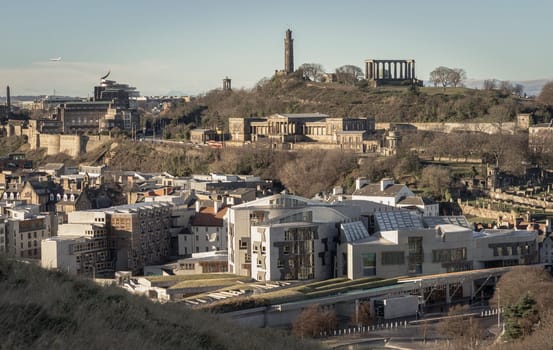 Edinburgh, Scotland - Jan 17, 2024 - Aerial view of Calton Hill, Scottish Parliament Building with the skyline seen from the top of Salisbury Crags. Amazing Edinburgh cityscape, Destinations in Europe, Copy space, Selective focus.