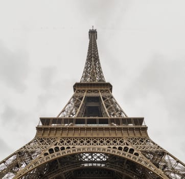 France, Paris - Jan 4, 2024 - Low angle shot of Famous Eiffel tower iron structure with white sky background. Architectural detail design of the Eiffel tower in Paris. Paris Best Destinations in Europe, Space for text, Selective focus.