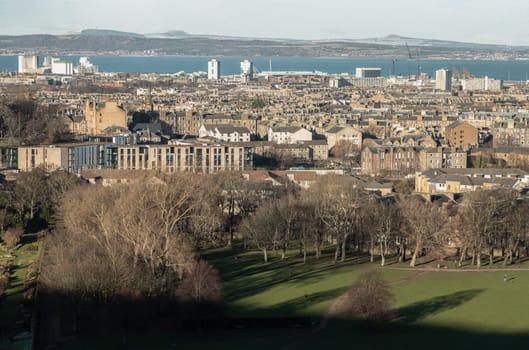 Edinburgh, Scotland - Jan 17, 2024 - Amazing Edinburgh Cityscape with Holyrood Park and Leith docks seen from the top of Salisbury Crags. Destinations in Europe, Space for text, Selective focus.