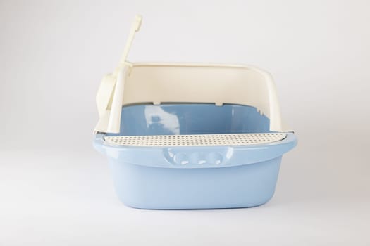 This isolated plastic cat litter toilet tray with scoop on a white background is essential for promoting hygiene and cleanliness in your pet's crate.