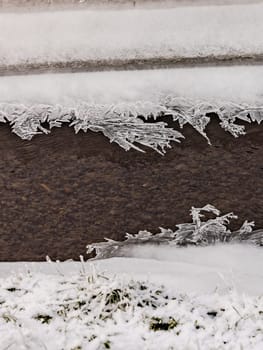 Snow and striking ice crystals after an icy rainfall on a ditch in the wild nature