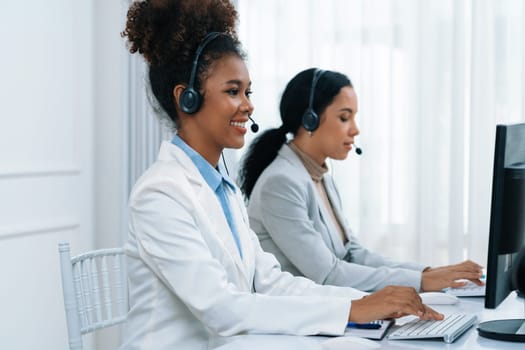 Business people wearing headset working in office to support remote customer or colleague. Call center, telemarketing, customer support agent provide service on telephone video conference call crucial