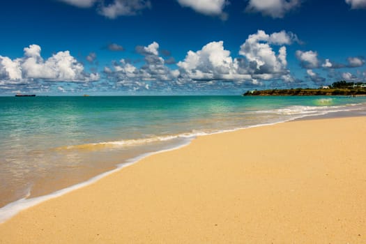 Caribbean beach with white sand, deep blue sky and turquoise water