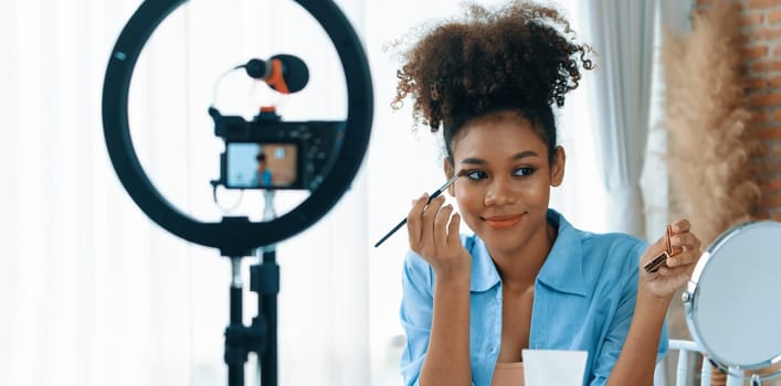 Woman influencer shoot live streaming vlog video review makeup crucial social media or blog. Happy young girl with cosmetics studio lighting for marketing recording session broadcasting online.