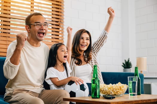 With popcorn in hand, a family of fans watches a football match on TV, fostering togetherness and excitement. Their cheers and laughter capture the joy of the game and celebrating a triumph.