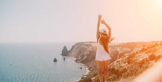 Woman travel sea. Young Happy woman in a long red dress posing on a beach near the sea on background of volcanic rocks, like in Iceland, sharing travel adventure journey