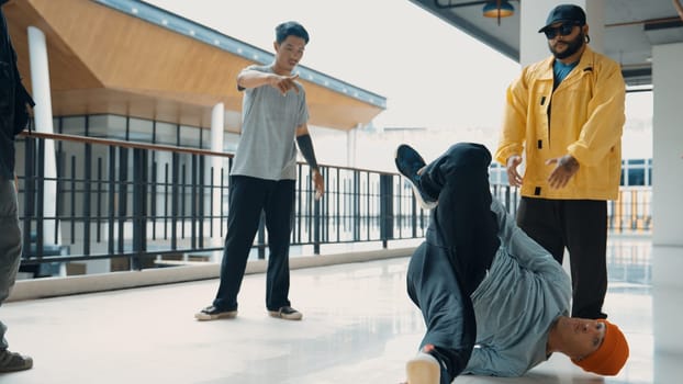 Hip hop team dance break dance while multicultural friend surrounded and clapping hands to cheer or encourage his friend to dance. Active and energetic street dance. Outdoor sport 2024. Endeavor.