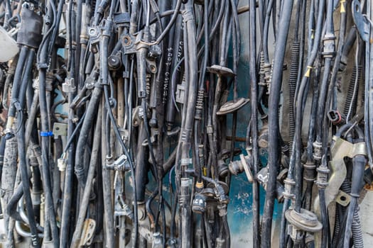 used car tubes and electrical wires hanging on the wall at junkyard market Kudaybergen, Bishkek, Kyrgyzstan - November 11, 2022