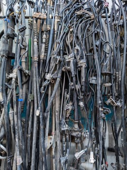 used car tubes and electrical wires hanging on the wall at junkyard market Kudaybergen, Bishkek, Kyrgyzstan - November 11, 2022