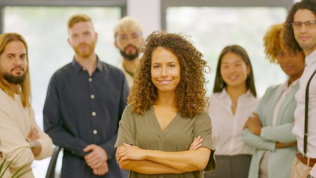 Woman leading a group of coworkers standing proud in the office