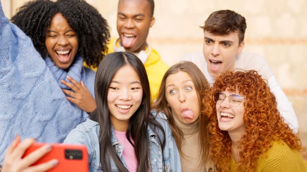 Group of friends taking a selfie outdoors making funny faces