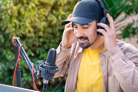 Young man recording radio podcast talking during live stream session outdoor. High quality photo