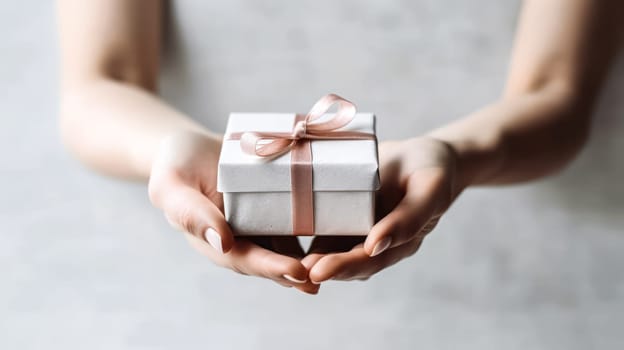 Express love with a tender touch as a girl holds a cute gift box in her hands on a light background, creating a heartfelt Valentines Day concept.