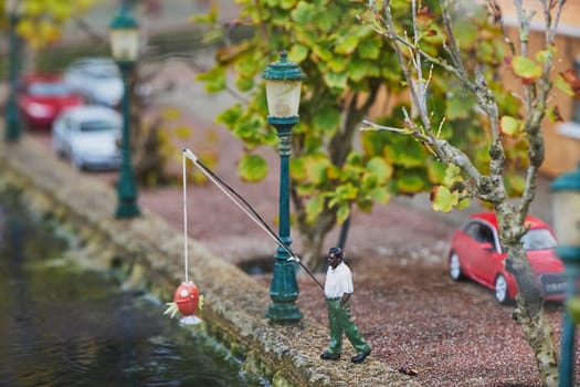 Miniature local man fishing in the canal in amusement park in the Netherlands