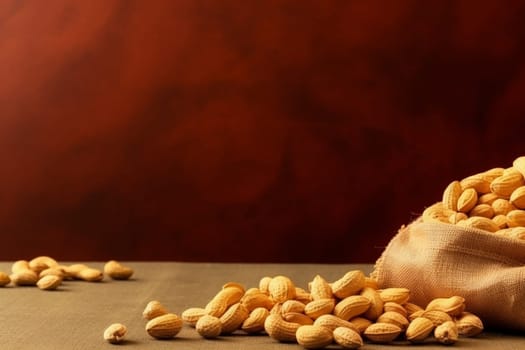 A sack of almonds spilled on a table against a dark background.