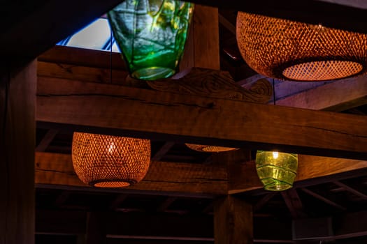 A warm and inviting scene of amber lanterns suspended from a wooden ceiling, casting a soft and enchanting light throughout the cozy indoor space