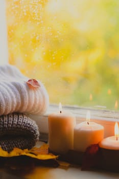 A burning candle on the window is autumn . the comfort of home . autumn comfort . autumn mood. The chondra .