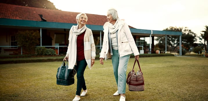 Retirement, hobby and senior woman friends walking on a field at the bowls club together for a leisure activity. Smile, talking and elderly people on the green of a course for bonding or recreation.