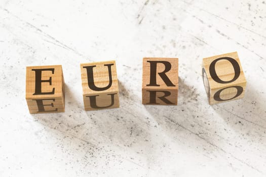 Four wooden cubes with word EURO on white working board