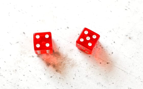 Two red craps dices showing Centerfield Nine / Nina (number 4 and 5) overhead shot on white board