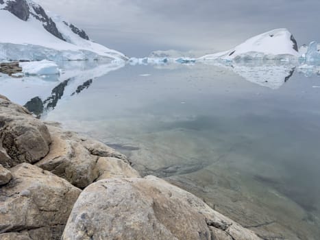 A huge high breakaway glacier in the southern ocean off the coast of Antarctica, the Antarctic Peninsula, the Southern Arctic Circle, azure water, cloudy weather. High quality photo