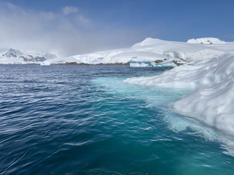 A huge glacier in the southern ocean off the coast of Antarctica, the Antarctic Peninsula, the Southern Arctic Circle, azure water, sunny weather. High quality photo