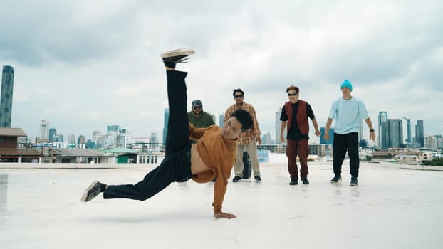 Professional break dance team practice B-boy dance while multicultural friends at rooftop. Young modern dancing group doing hip hop movement. Style,fashion,action. Outdoor sport 2024. Endeavor.