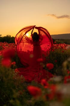 Woman poppy field red dress sunset. Happy woman in a long red dress in a beautiful large poppy field. Blond stands with her back posing on a large field of red poppies.