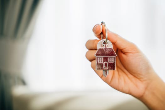 A female hand displays a house key symbolizing confidence and success in homeownership. Reflecting happiness achievement and the excitement of a new investment.