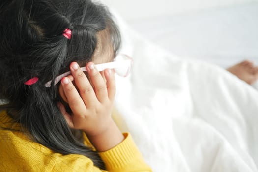 child having ear pain touching his painful ear