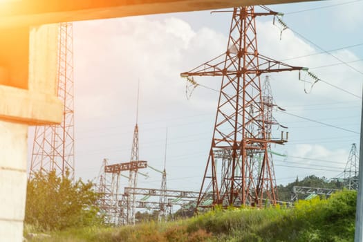 High voltage towers with sky background. Power line support with wires for electricity transmission. High voltage grid tower with wire cable at distribution station. Energy industry, energy saving.