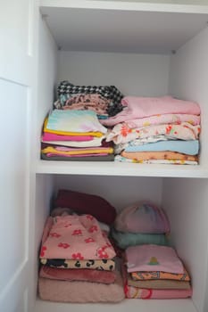 stack child cloths on a shelf