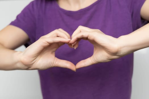 Inspire inclusion. Zoomers symbolize love. Woman finger heart dressed purple t-shirt. Hand showing heart. International Women's Day 2024, InspireInclusion